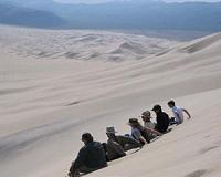 Physics of booming and burping sand dunes revealed