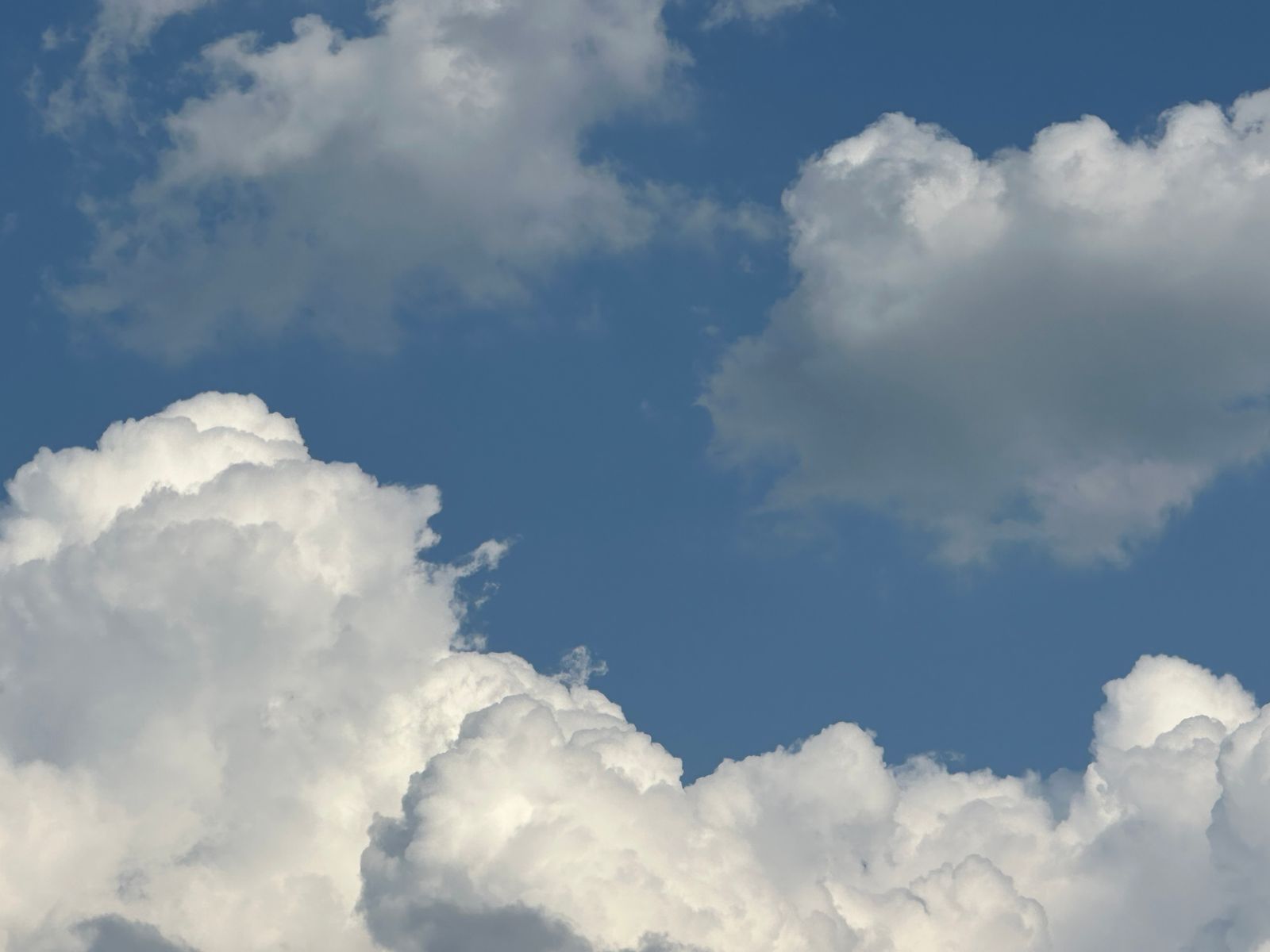 A single cumulus cloud weighs roughly 500 tonnes, about the mass of 100 elephants, and it floats because the warm air holding those water droplets is still less dense than the cooler, heavier air pressing up beneath it.