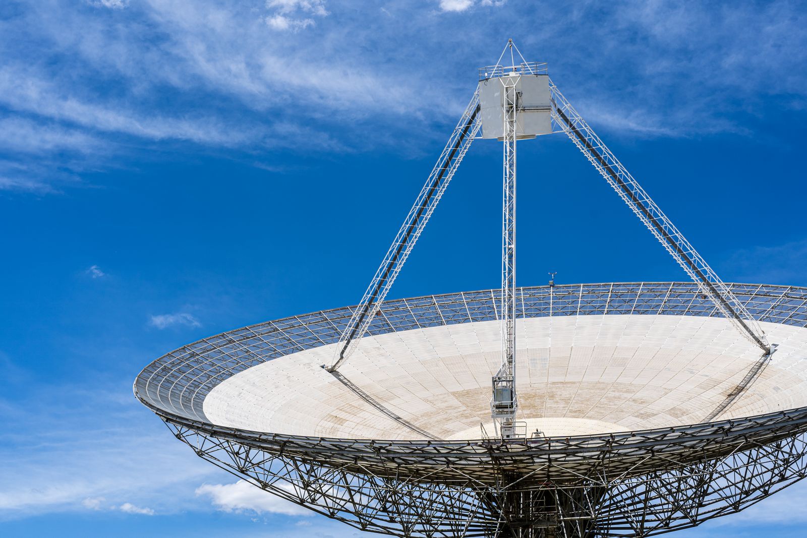 How does a spacecraft launched in 1977 keep transmitting from beyond the heliosphere on less electrical power than a single hallway bulb, and why does its signal now take more than 22 hours to reach Earth?
